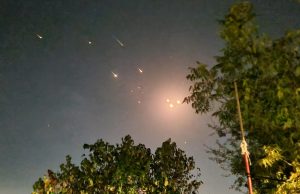Iran Missiles Hit Israel in 2024 Escalation Missiles streak across the sky above a city skyline during an Iran-Israel military confrontation in 2024.