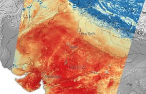 Heat Wave Hits India, Pakistan Affecting Millions A crowded street in India with people seeking shade under umbrellas during a severe heat wave