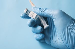 Moderna Wins US Approval for Updated COVID Vaccine Mnexspike A vial of Moderna's Mnexspike COVID-19 vaccine on a laboratory counter with a syringe nearby, symbolizing the new regulatory approval.