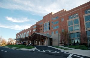 NYT Probes Ascension Aggressive Medical Debt Collection A patient reviews a medical bill in a hospital lobby, highlighting the financial burden of healthcare costs.