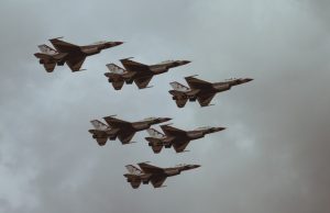 Pentagon Releases 2024 Syria UAP Video Report A U.S. military aircraft flies over a desert landscape during an intelligence mission, with a bright white light visible in the sky.