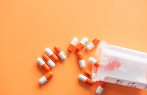 Takeda Drug Oveporexton Targets Orexin in Narcolepsy Shift A scientist examines a molecular model of the orexin OX2 receptor in a laboratory setting.