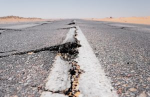 Ojai 5.1 Quake Reopens California Seismic History Cracked asphalt on a quiet Ojai street after the 2023 quake, with residents inspecting minor damage under sunny skies.