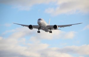 One Bad Line of Code Strands Thousands of Airline Passengers Passengers waiting at a crowded airport gate with delayed flight information on a screen