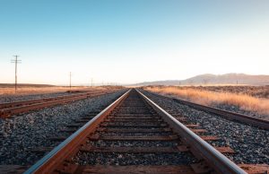 13 Die in Jalgaon After Fleeing Train onto Track A train passes through Jalgaon station in Maharashtra, with tracks and platforms visible in the scene.