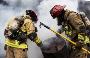 Hyderabad Building Fire Kills 17, Injures Several Firefighters and emergency vehicles at the site of a building fire in Hyderabad, with smoke rising over the Hussain Sagar lake.