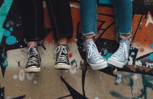 Australia Adds YouTube to Teen Social Media Ban Australian teenagers using smartphones on a couch, with YouTube app icon visible on one screen, reflecting the upcoming ban.