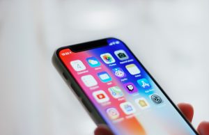 OpenAI Adds Voice and Vision to ChatGPT A person speaks into a smartphone while ChatGPT responds with spoken words on the screen.