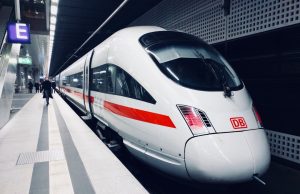 Whoosh Rail Carries 2.56M Passengers in First 6 Months A high-speed train speeds past green Indonesian countryside, with passengers boarding at a modern station.
