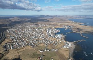 Iceland Volcano Erupts Near GrindavÃk, Fissure Inside Town Aerial view of a volcanic fissure emitting lava near the town of GrindavÃk, Iceland, with smoke rising over residential areas.