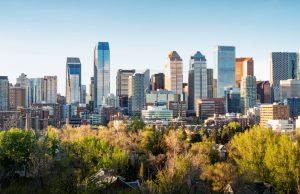 Calgary Air Quality Hits High Risk From Wildfire Smoke Smoke haze obscures Calgary skyline with Bow River and Rocky Mountain foothills in background