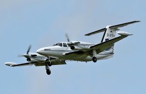 Brazil Plane Crash Kills 10, Injures 17 Emergency responders at the crash site of a Piper PA-42 Cheyenne in Gramado, Brazil, with damaged shops and a hotel in the background.
