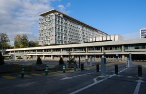 WHO Probes China Child Pneumonia Surge World Health Organization headquarters in Geneva with a flag and modern building exterior