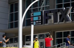 FTX Files Chapter 11 After $8B Liquidity Hole Empty FTX trading floor desks lit by blue screens as staff exit after bankruptcy filing