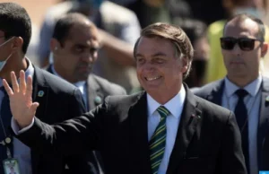 Bolsonaro Ends Brazil Presidency After 4-Year Term Jair Bolsonaro stands before the Brazilian flag at the end of his presidential term, July 2023.