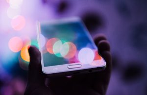 OpenAI Launches ChatGPT iPhone App A person holds an iPhone displaying the ChatGPT app interface with a text input field and response area.