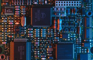 South Korea Chip Inventories Surge 28% in January Workers in cleanroom suits inspect semiconductor wafers at a South Korean chip fabrication plant.