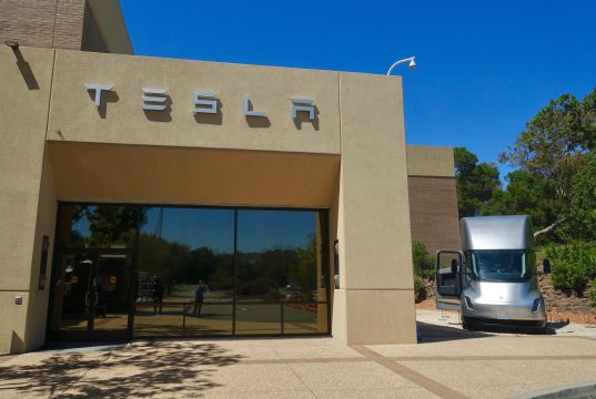 Tesla Kicks Off Semi Volume Production April 2026 Tesla Semi electric truck parked outside Giga Nevada factory, ready for freight transport
