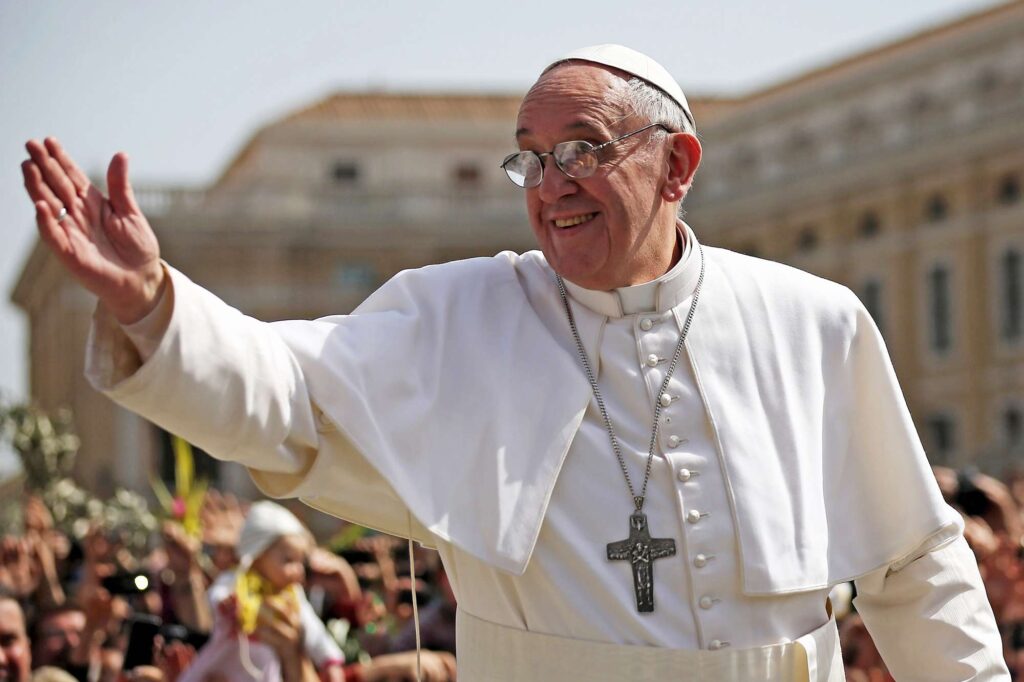 Pope Francis waves from balcony of St Peter’s Basilica in white papal robes under clear sky